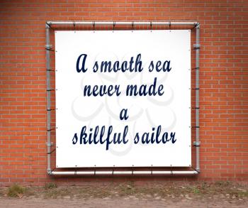 Large banner with inspirational quote on a brick wall - A smooth sea never made a skillful sailor