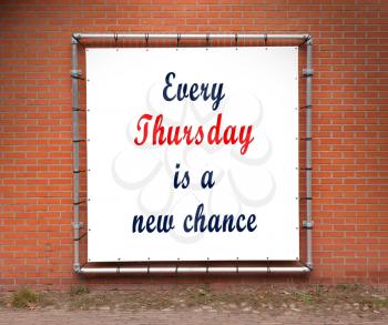 Large banner with inspirational quote on a brick wall - Every thursday is a new chance