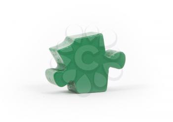 Closeup of big green jigsaw puzzle piece isolated on white