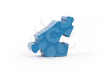 Closeup of big blue jigsaw puzzle piece isolated on white