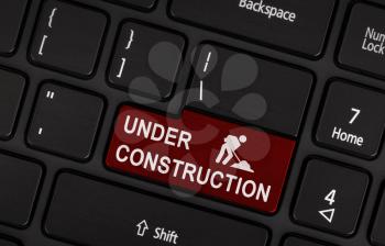 Under construction - Maintenance icon on black laptop keyboard button