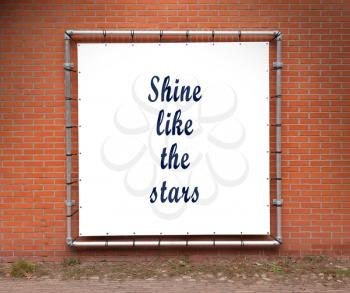 Large banner with inspirational quote on a brick wall - Shine like the stars