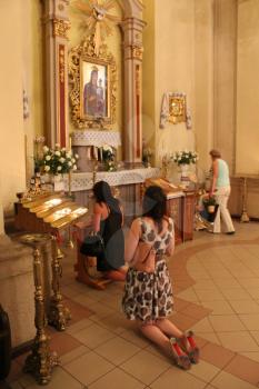people kneeling and praying in the hall of Catholic church