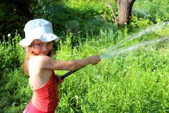 girl watering a kitchen garden in the country