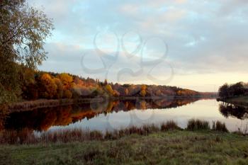 beautiful landscape with sunset, river and forest reflecting in it