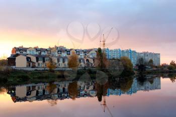 beautiful landscape with sunset, river and modern house reflecting in it
