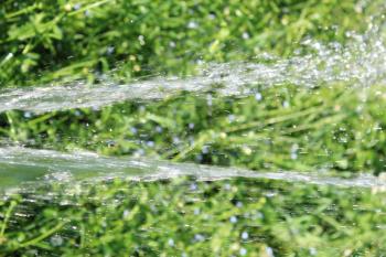 image with jet of falling water on the green background