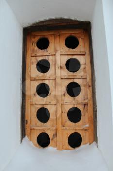 Ancient wooden window with a unusual pattern in a wall