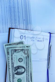 table with numerals, calculator, pen and american dollars