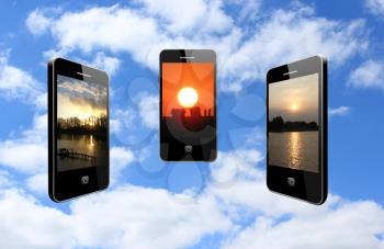 three modern mobile phones with different sunsets