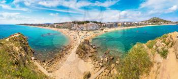 Tourists enjoy at the beach in Blanes in Costa Brava in a beautiful summer day, Spain