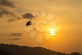 Para sailing during sunset at Patong beach and Andaman sea on Phuket in Thailand in a summer day