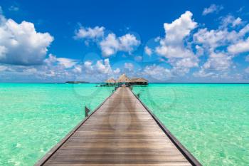 MALDIVES - JUNE 24, 2018: Water Villas (Bungalows) and wooden bridge at Tropical beach in the Maldives at summer day