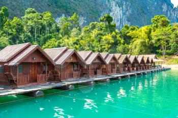 Traditional Thai bungalows at Cheow Lan lake, Ratchaprapha Dam, Khao Sok National Park in Thailand in a summer day