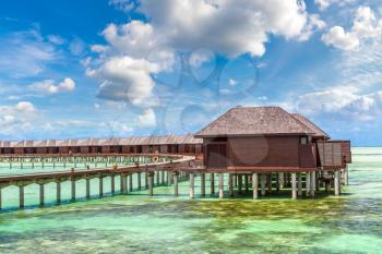 MALDIVES - JUNE 24, 2018: Water Villas (Bungalows) and wooden bridge at Tropical beach in the Maldives at summer day