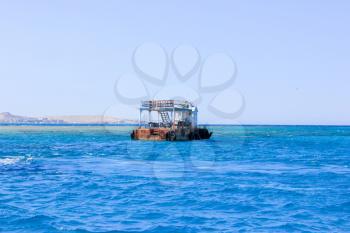 Old Rusty Barge floating on the Sea. Sea Blue Water Background.