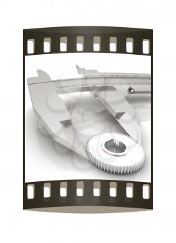 Vernier caliper measures the cogwheel on a white background. The film strip