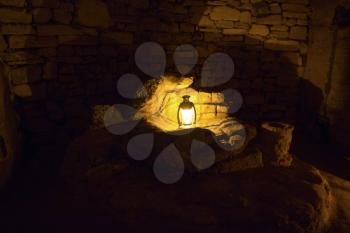 Futuristic electric street lamp glowing in a dark stone cave.