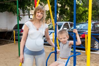 Photo of happiest pregnant mother and son on walk