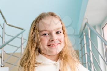 Portrait of cute girl with blond hair in white