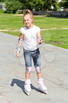 Photo of cute girl on roller skates in summer