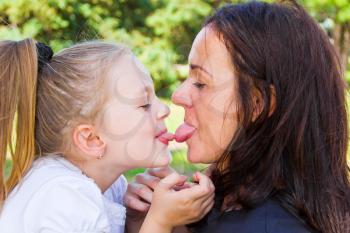 Photo of kissing mother and daughter in summer