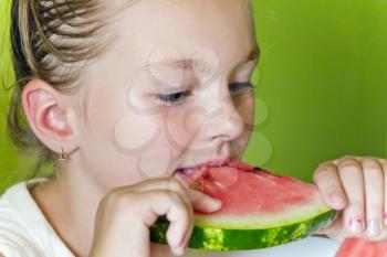 Photo of the cute girl eating watermelon