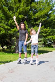 Photo of mother and daughter on roller skates in summer