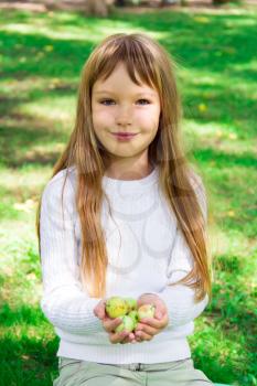 Photo of cute girl with apples in summer