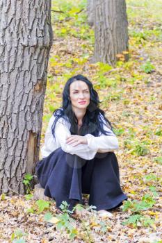 European brunette woman in white on gold autumn grass