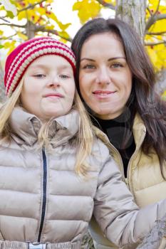 Mother and daughter on yellow foliage background