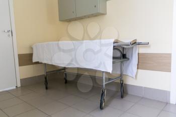 Photo of empty stretcher in hospital corridor