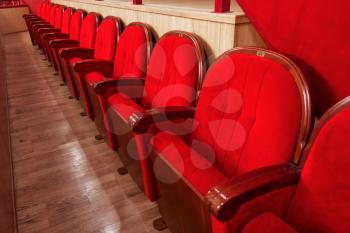 row of red velvet seats in the cinema theatre