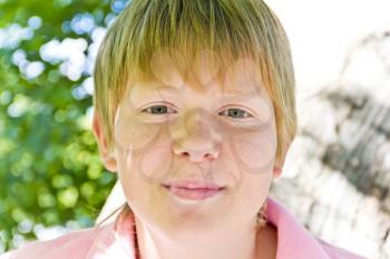 Portrait of blond boy in a pink shirt