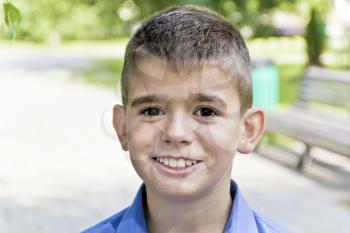 Cute brunette boy eleven years old in summer background