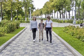 Happiest mother with daughter and son walking in summer
