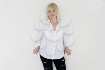 Blond woman in white and black jeans stand inside empty room