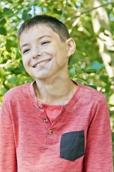 Smiling teenager boy in pink on green background