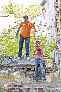 Father and teenager son are playing in ruins