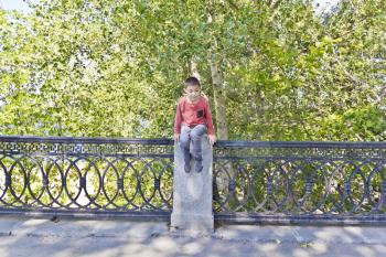 Teenager boy is jumping on green summer embankment