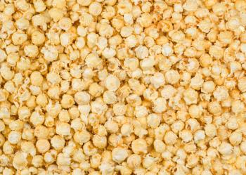 Scattered caramel popcorn, texture background. Backdrop for a web site, scrapbooking, packaging