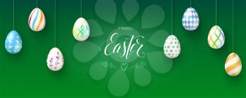 Happy Easter and goodness to you. Banner with festive greetings. Calligraphic handwritten text and wishes for season holidays. Easter eggs with hand painting patterns hanging on green background.