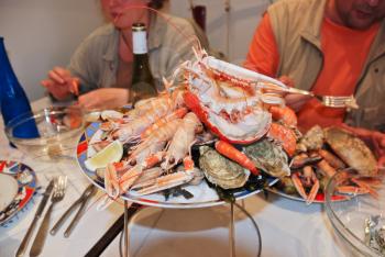 eating cut crab, oysters, shrimps and other seafood