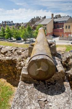 old cannon in medieval fort pointed at houses