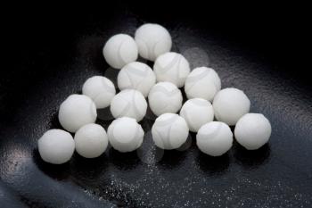 sugar homeopathy balls in black container close up