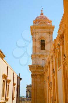 straight baroque style street with houses from yellow sandstone in Noto, Sicily