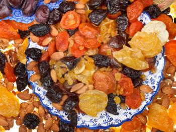 top view of many dried fruits on asian plates close up