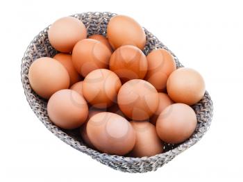 fresh chicken eggs in wicker basket isolated on white background