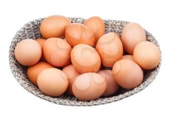 top view of fresh chicken eggs in wicker basket isolated on white background