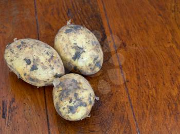 yellow raw potatoes on brown wooden table
